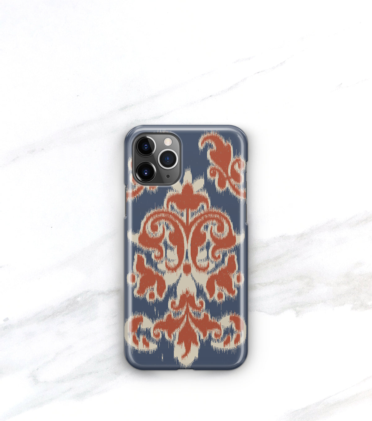 a phone case with a blue and orange patterned design, placed on a white marble surface.