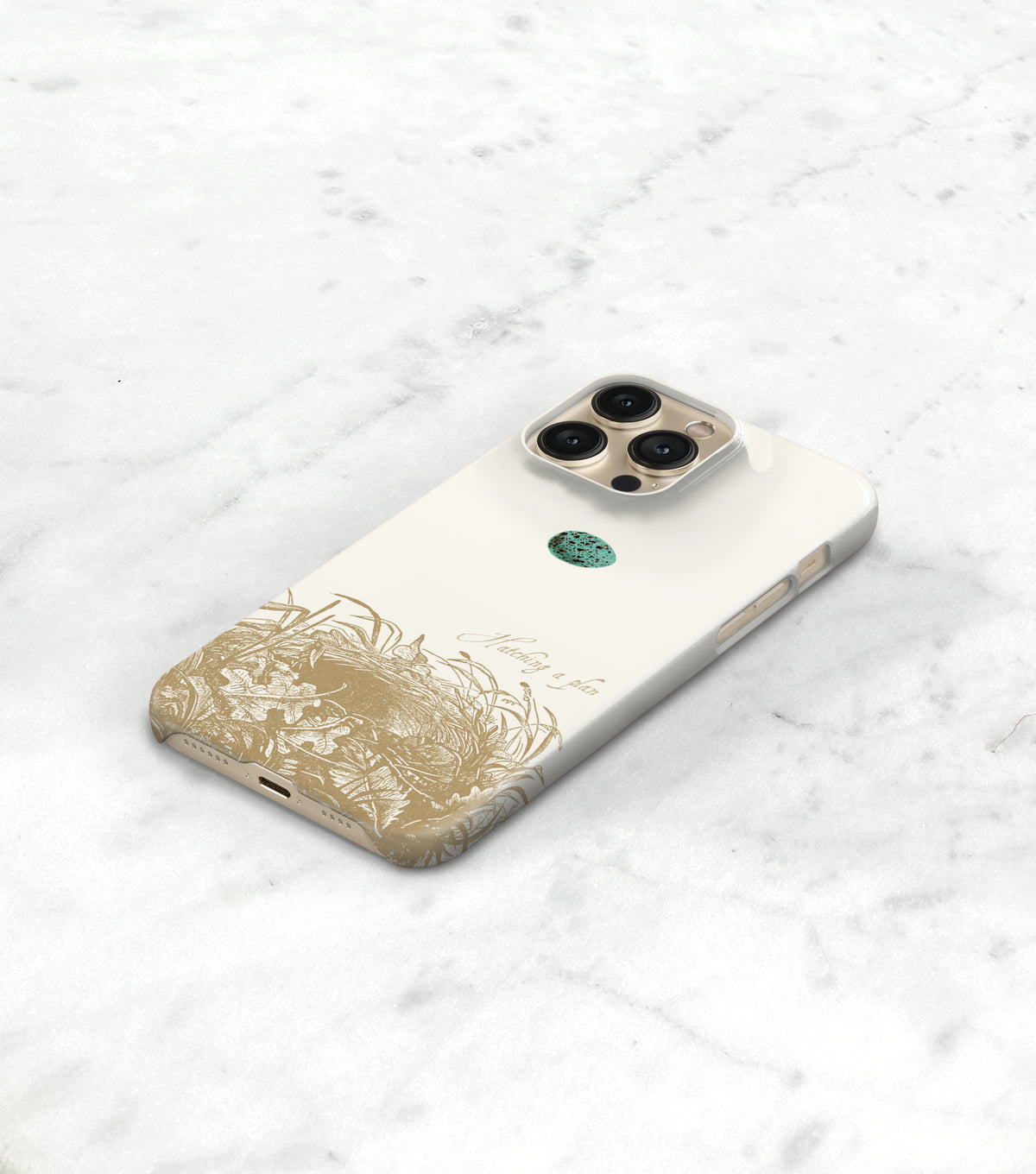 A white smartphone case with a gold floral design and a camera lens attached to it, placed on a white marble surface.