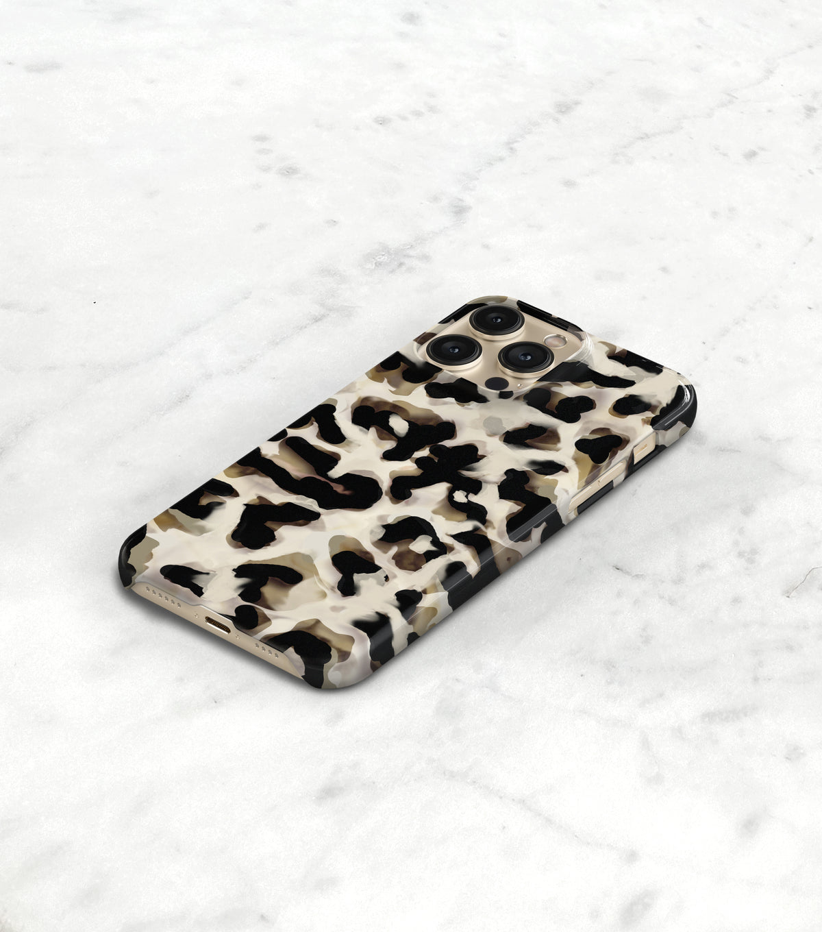 A leopard print phone case is lying on a white marble surface.