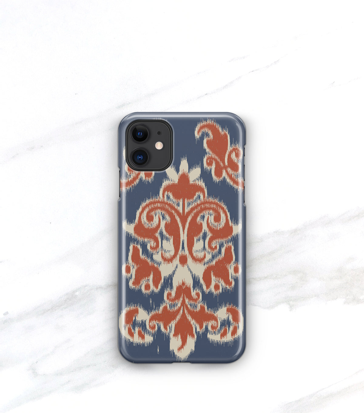 a phone case with a blue and orange patterned design, placed on a white marble surface.