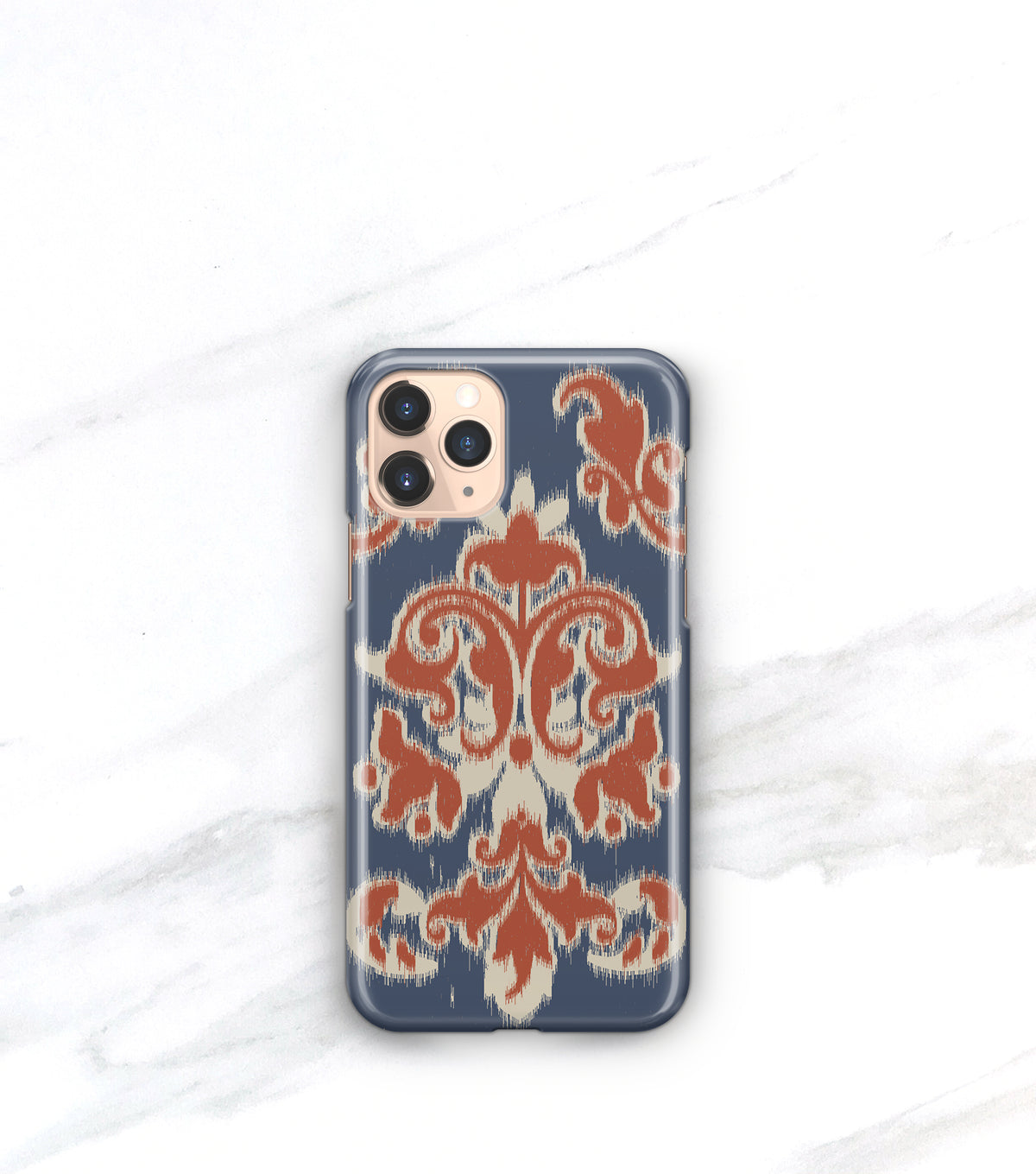 a phone case with a blue and orange patterned design, placed on a white marble surface.