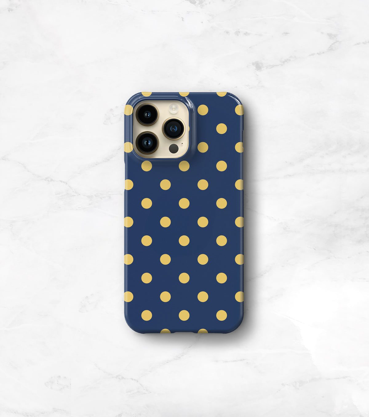 A blue phone case with yellow polka dots is placed on a white marble surface.