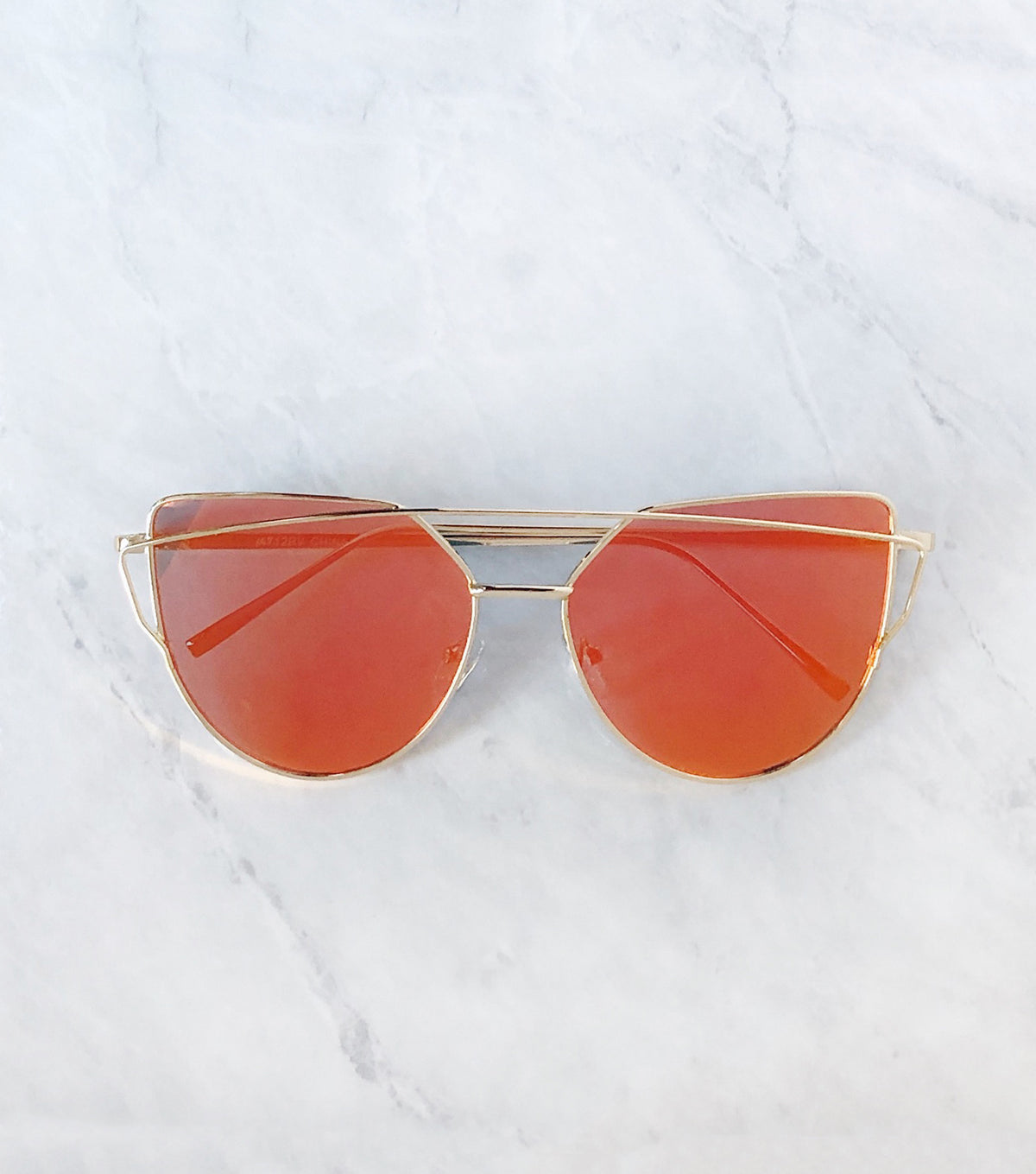 orange cat eye sunglasses with gold wire frame