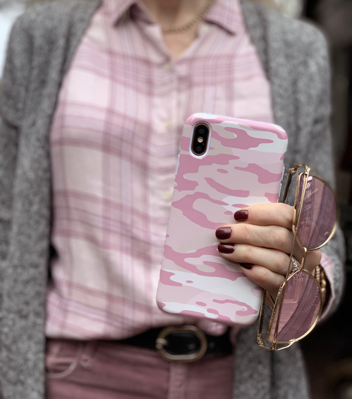 Pink camo phone case styled with sunglasses and plaid